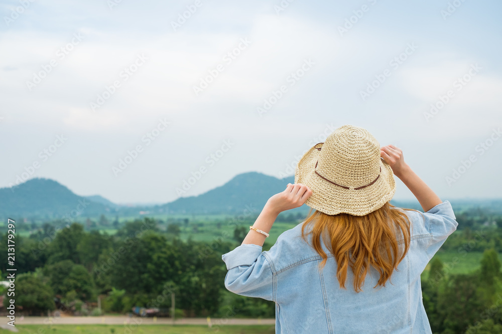 Fototapeta premium Young beautiful women hipster style wearing hat enjoy life looking mountain with blue sky.