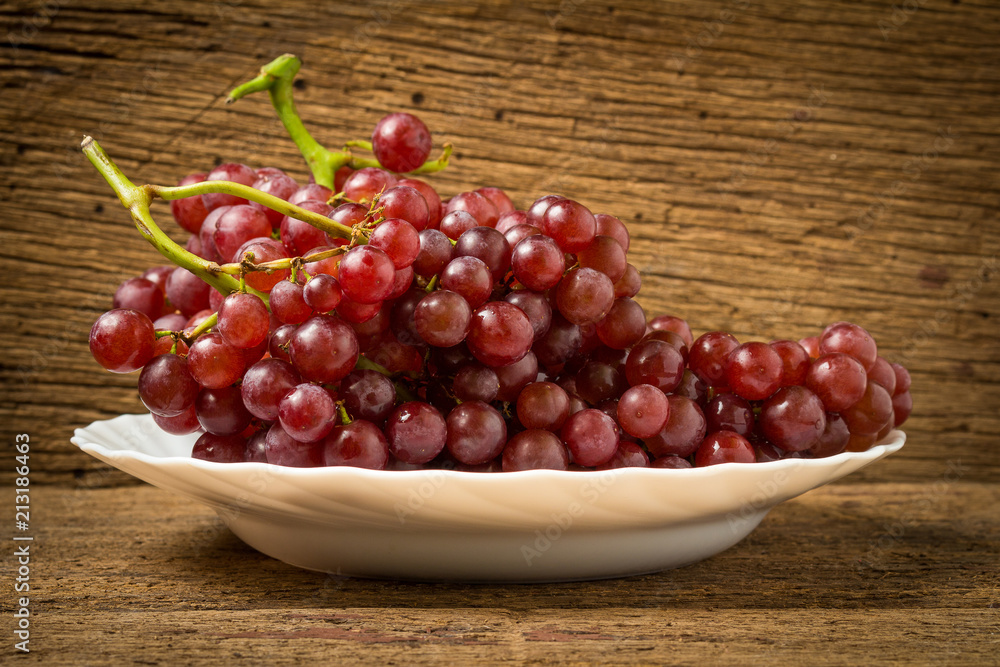 grapes seedless red on dish on old wood grapes seedless red on dish on old wood