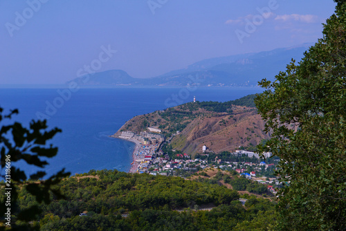 The coast of the resort town with hotels, restaurants and beaches in the background of the wide blue sea © adamchuk_leo