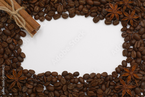 Background of coffee beans. Coffee texture. A place to write a text. Cinnamon sticks and cardamom.