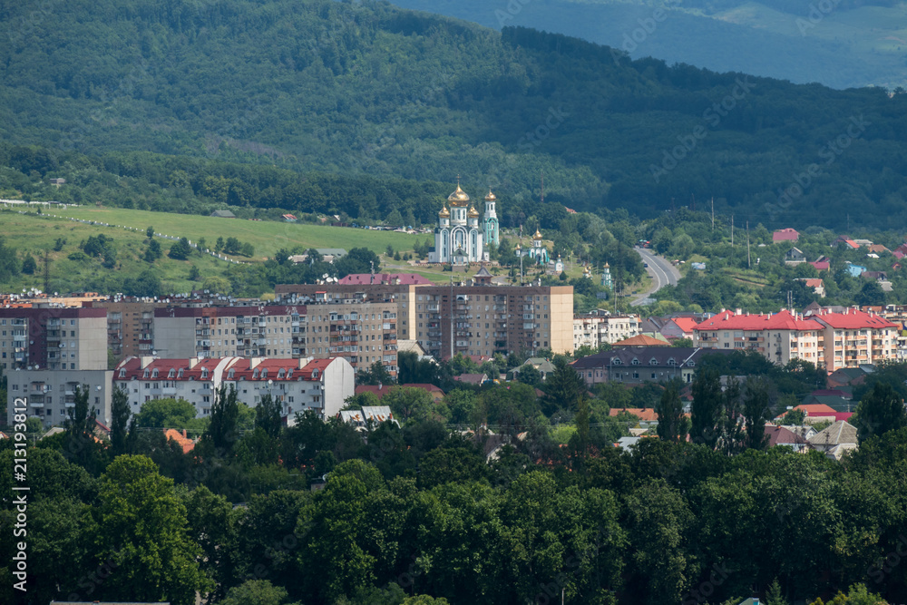 Naklejka premium houses with red roofs and a church with golden domes in the Carpathians
