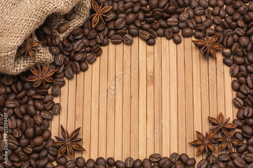 Background of coffee beans. Coffee texture. A place to write a text. Cinnamon sticks and cardamom.