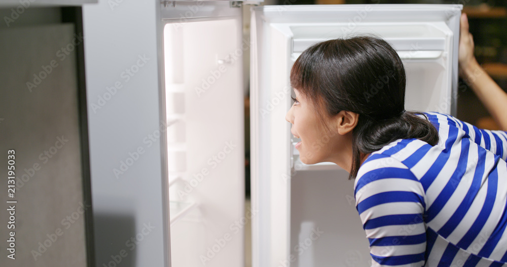 Woman opening the refrigerator and taking out a bottle of juice Woman opening the refrigerator and taking out a bottle of juice