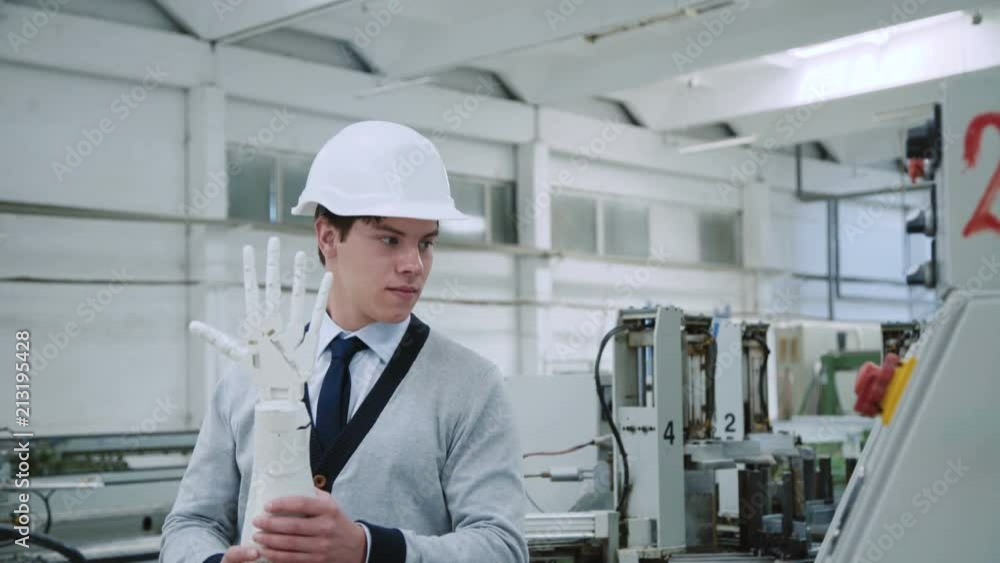The engineer examines a robot hand with control desk on the factory. 4K The engineer examines a robot hand with control desk on the factory. 4K