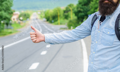 Autostop travel. Pick me up. Thumb up gesture try stop car road background. Hand gesture hitchhiking. Make sure you know right gestures to stop car. Thumb up sign not work in many parts of world photo