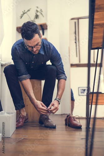 Man sitting to do up his shoelaces.