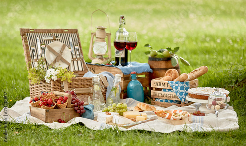 Fototapeta Naklejka Na Ścianę i Meble -  Blanket with picnic food set on green grass