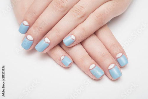 Blue manicure in light and dark colors of lacquer on a striped background.