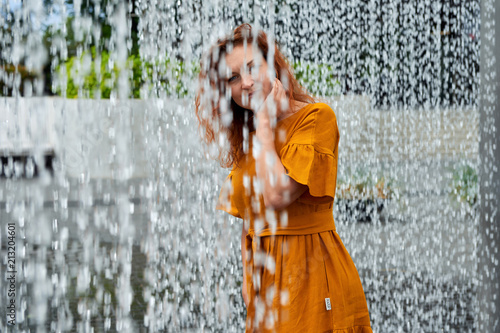 Young woman wearing a multicolored dress in a water bath.