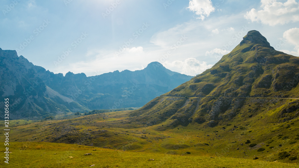 Obraz premium Gorgeous panoramic view of mountains in cloudy day with few peaks and road, autumn Montenegro, Durmitor national park