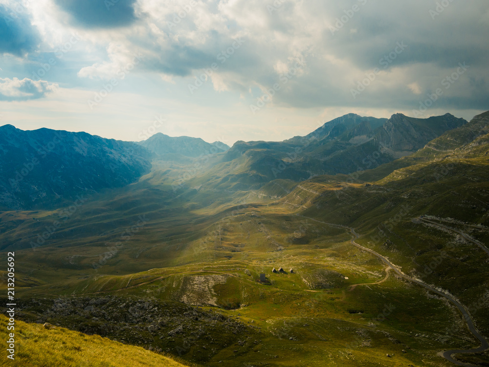 Fototapeta premium View on a valley in Durmitor national park, Montenegro, in cloudy day with sunlight shining through the sky