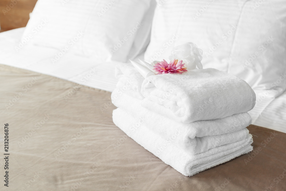 towels and flower on bed in hotel room towels and flower on bed in hotel room