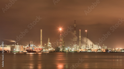 Landscape of the vast harbor area with Illuminated petrochemical production plant, Antwerp, Belgium.
