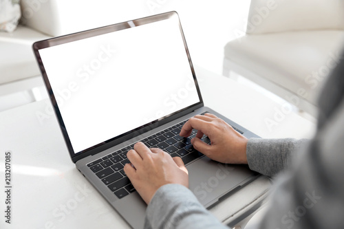 Women using laptop with blank screen at table in the office.