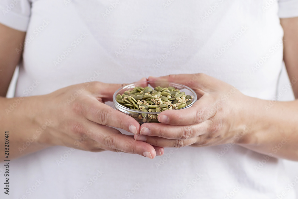 A person holding a bowl with seeds A person holding a bowl with seeds
