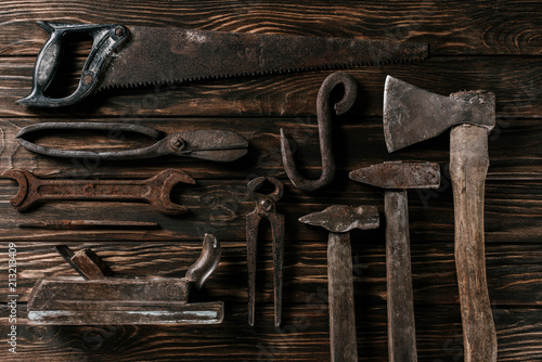 flat lay with assortment of vintage rusty carpentry tools on wooden surface