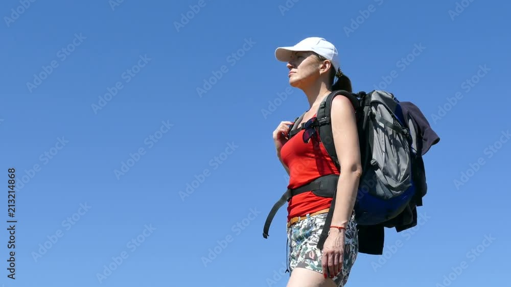 4K. Womanl tourist with backpack stand outdoor. Summer blue sky 4K. Womanl tourist with backpack stand outdoor. Summer blue sky