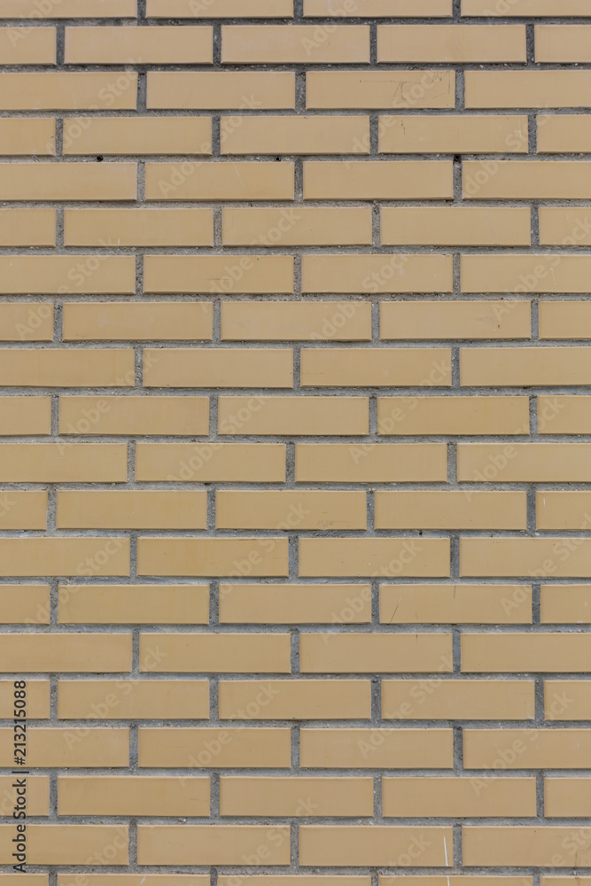 Yellow with grey seams stone bricks wall pattern texture background vertical shot Yellow with grey seams stone bricks wall pattern texture background vertical shot