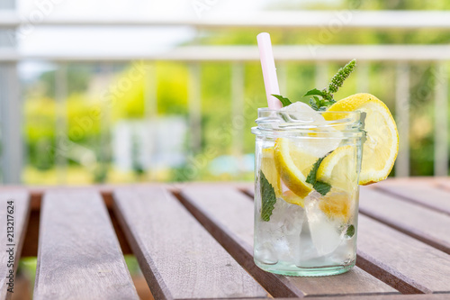 Frische selbstgemachte Zitronenlimonade auf einem Holztisch im Garten  photo