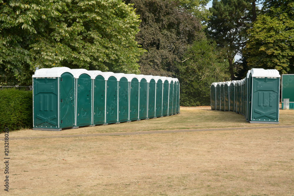 Rows of green portaloos or platic mobile toilets at festival Rows of green portaloos or platic mobile toilets at festival
