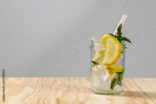 Frische limonade mit frischen Zitronen und Eiswürfeln in einem Glas mit Strohhalm