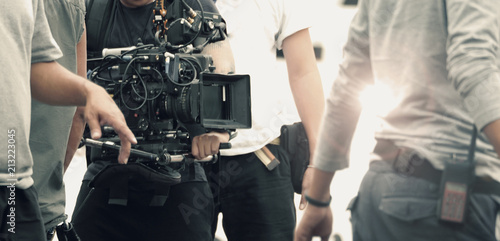 Obraz na plátně Blurred images of high definition video camera and lens on steady equipment support such as gimbal steady or stabilized shoulder rig and pan tilt shift head tripod for handheld filming moving object