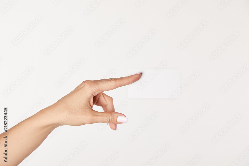 partial view of businesswoman showing blank business card isolated on white background