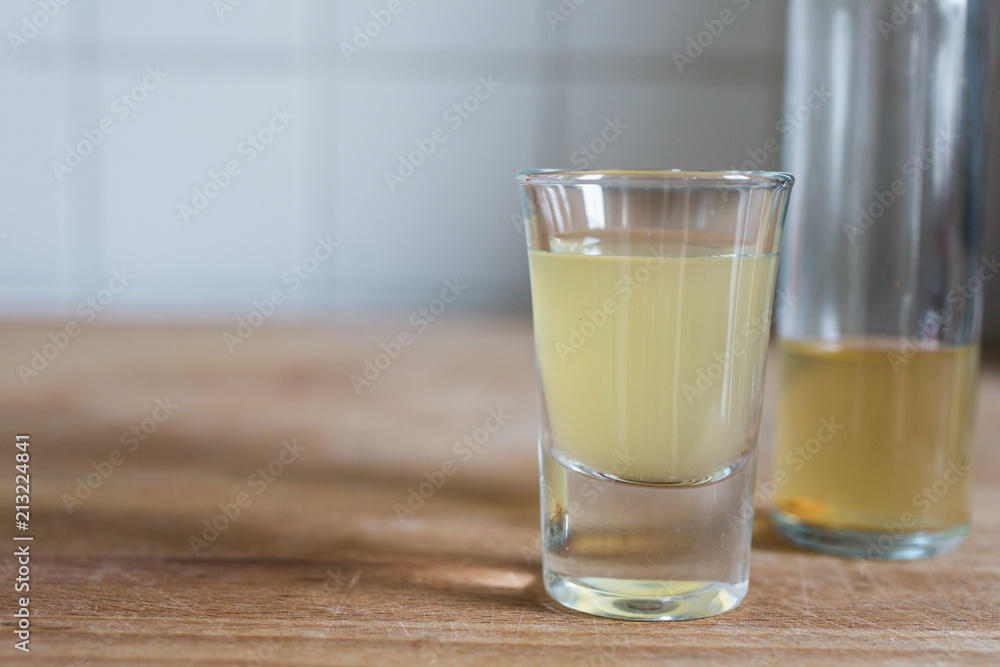 a glass and bottle with clarifying, detoxing apple cider vinegar for health benefits on wooden table a glass and bottle with clarifying, detoxing apple cider vinegar for health benefits on wooden table