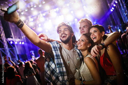 Happy friends taking selfie at music festival