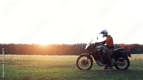 Biker Man sit and ride on the tourist motorcycle outdoor sunset, copy space, travel concept, adventure touring, enjoy momment,  photo
