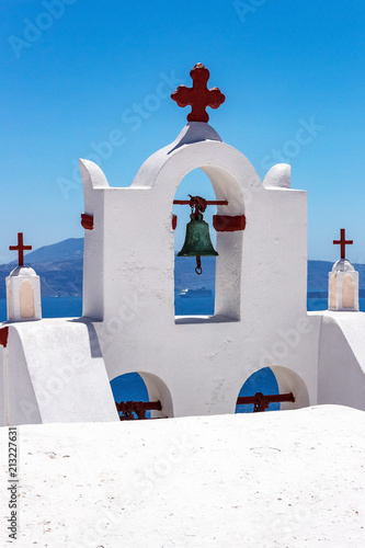 Greek Churchbells with cruiseship in background in deep blue sea