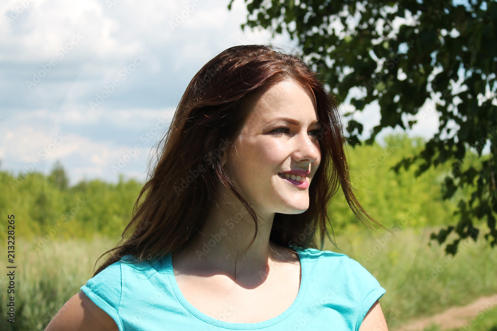 portrait of a smiling girl with dark hair in profile on nature background portrait of a smiling girl with dark hair in profile on nature background