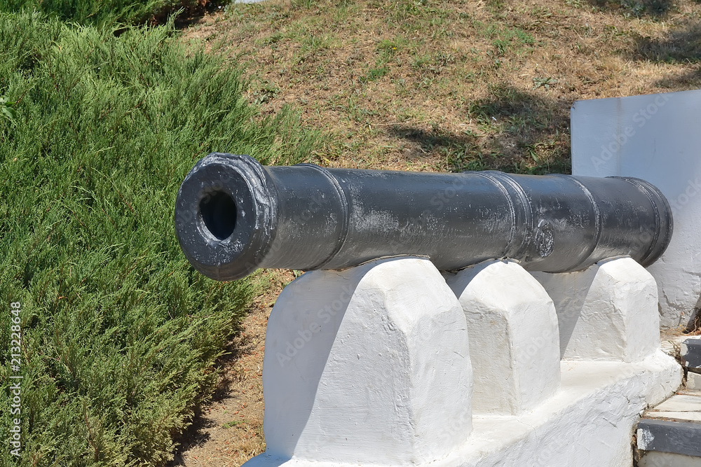 The barrel of an old gun on a pedestal