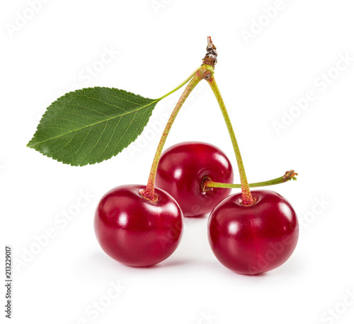 Three ripe cherries on stem with leaf isolated on white background