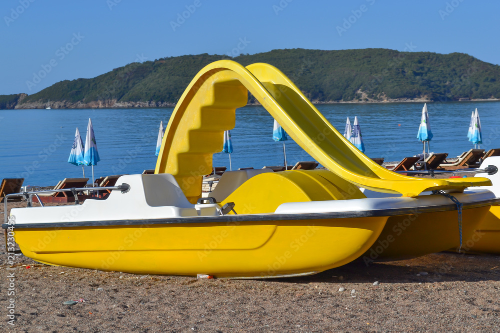Yellow catamaran on the beach. Preparation for the beach season. Entertainment at sea. Yellow catamaran on the beach. Preparation for the beach season. Entertainment at sea.