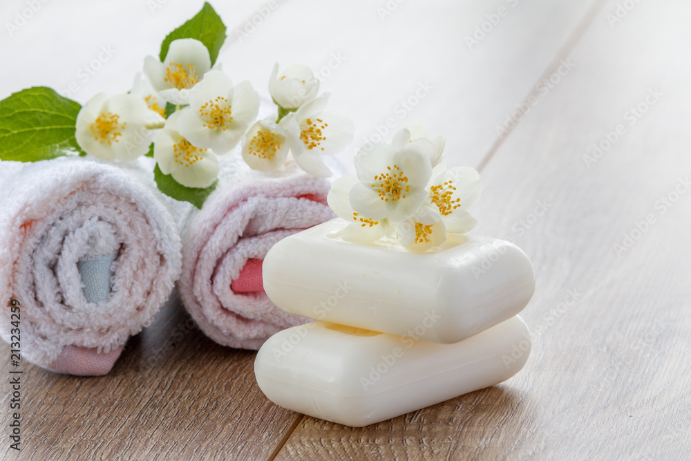 White towels and soap for bathroom procedures and flowers of jasmine on wooden boards White towels and soap for bathroom procedures and flowers of jasmine on wooden boards