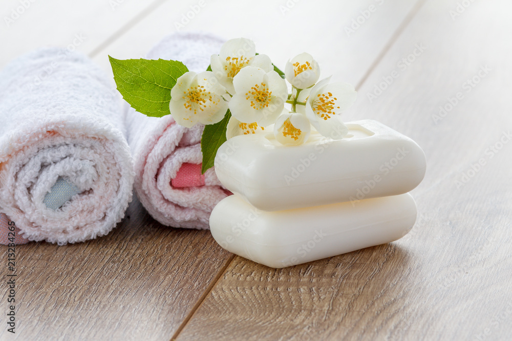 White towels and soap for bathroom procedures and flowers of jasmine on wooden boards White towels and soap for bathroom procedures and flowers of jasmine on wooden boards