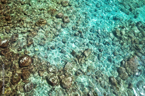 sea water with sunlight on turquoise pebbles