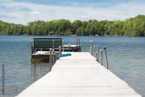 Wooden dock and a bench on a quiet lake photo