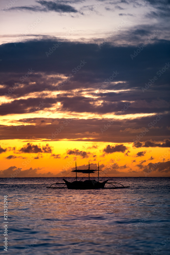 fishing boat sailing along sunset