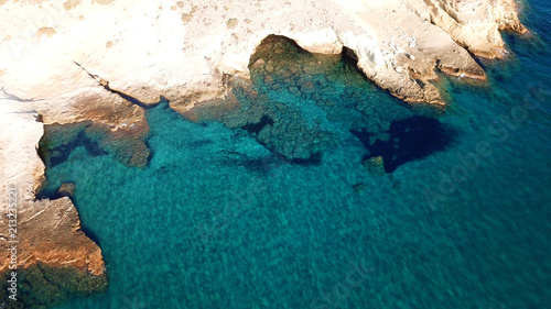 Aerial drone bird's eye view of iconic lunar volcanic white chalk caves and beach of Kapros next to famous caves of Papafragas, Milos island, Cyclades, Greece