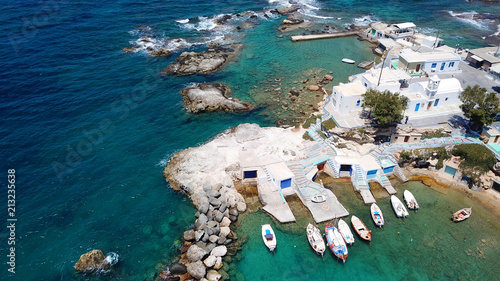 Aerial drone bird's eye view photo of picturesque small fishing harbor of Mandrakia with boat houses called syrmata and fishing boats docked on turquoise clear waters, Milos island, Cyclades, Greece photo