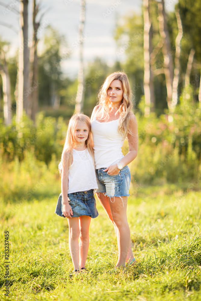 Family picture of blonde young mother and daughter outdoors Family picture of blonde young mother and daughter outdoors