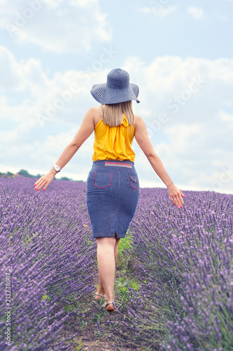 Fototapeta Naklejka Na Ścianę i Meble -  Woman is walking along the lavender field.