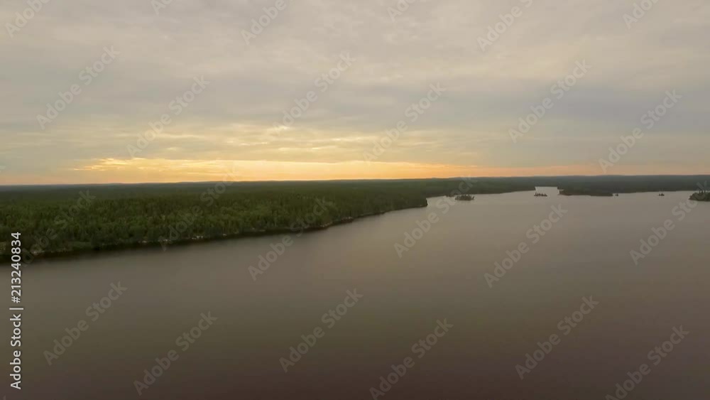 Aerial drone shot rising slowly over a vast remote and beautiful lake in Ontario, Canada, at sunset. Aerial drone shot rising slowly over a vast remote and beautiful lake in Ontario, Canada, at sunset.