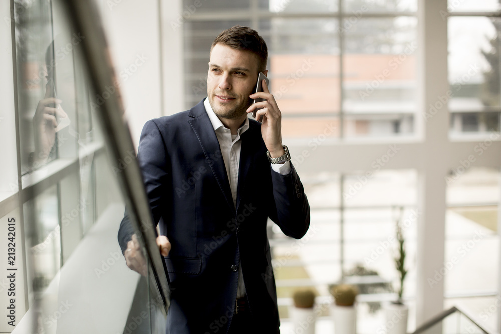 Handsome businessman using smartphone in the office Handsome businessman using smartphone in the office