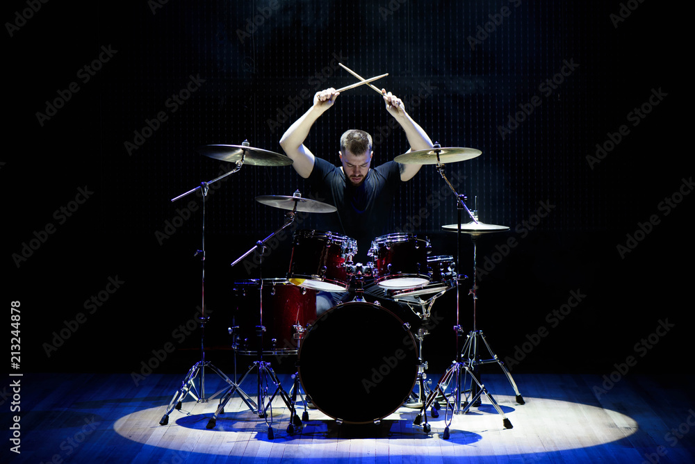 Fototapeta premium Drummer playing the drums with smoke and powder in the background