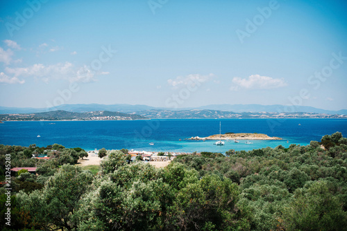 Aerial view of Green forest and blue and turquoise water in Mediterranean sea on sunny summer day in Greece © WellStock