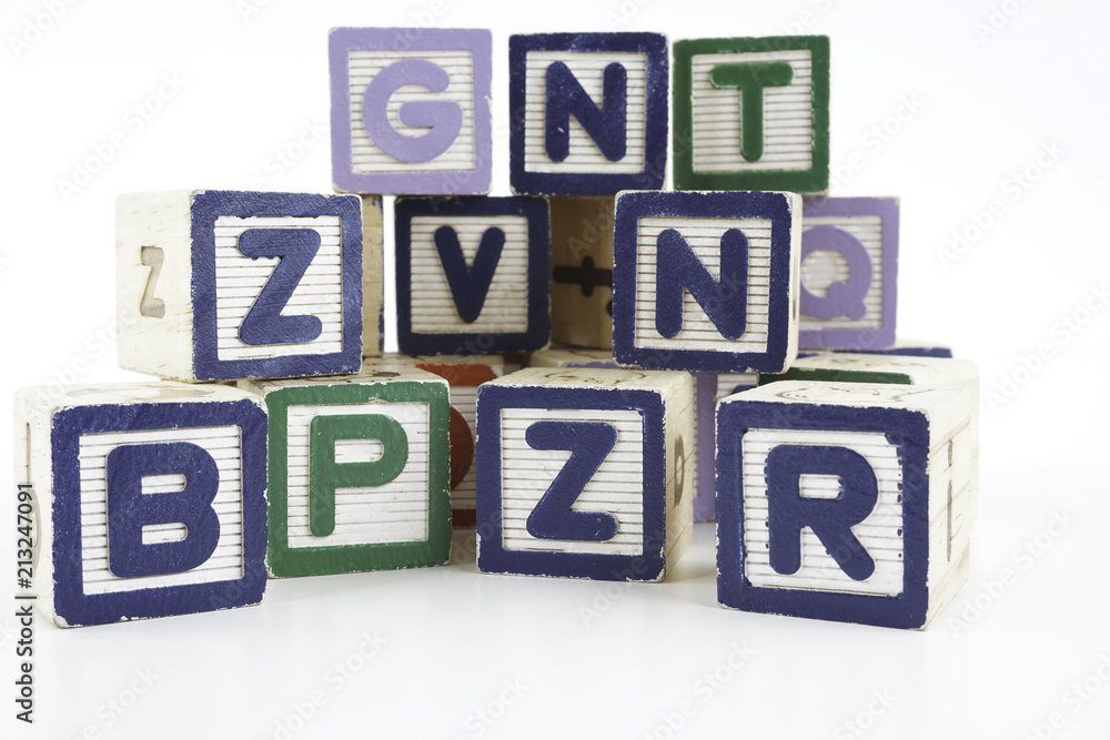 Colored wooden letter blocks on a white background with copy space Colored wooden letter blocks on a white background with copy space