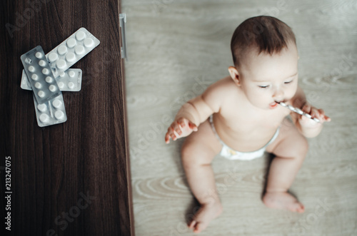 baby, girl sitting on the floor in the hands of pills photo